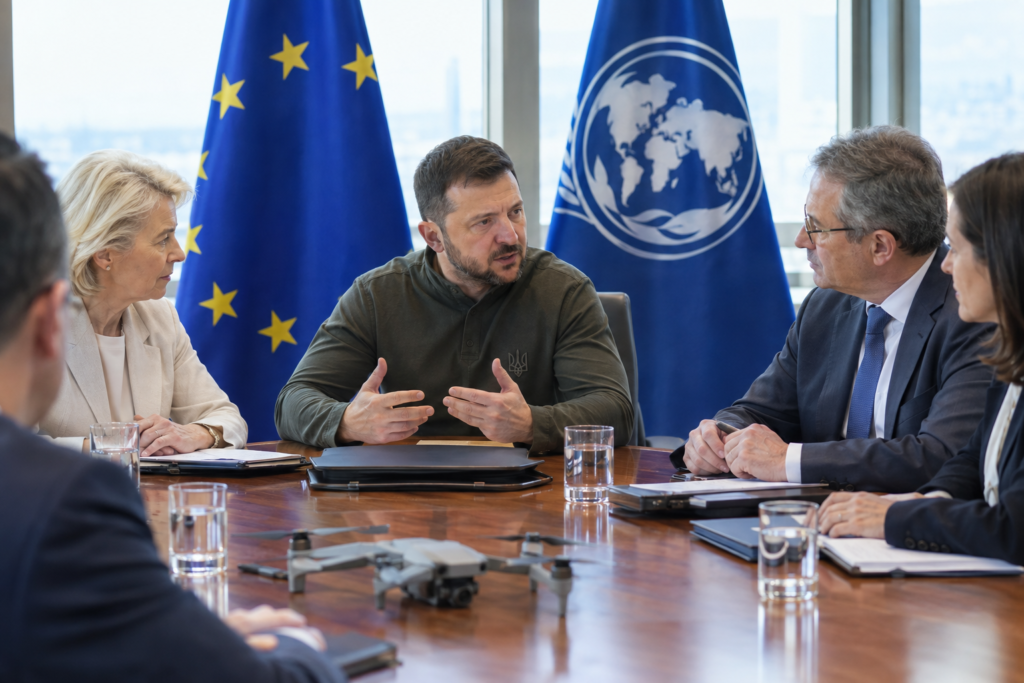 Президент у розмові з міжнародними посадовцями, на задньому плані прапори ЄС і МВФ, наголос на фінансуванні дронів