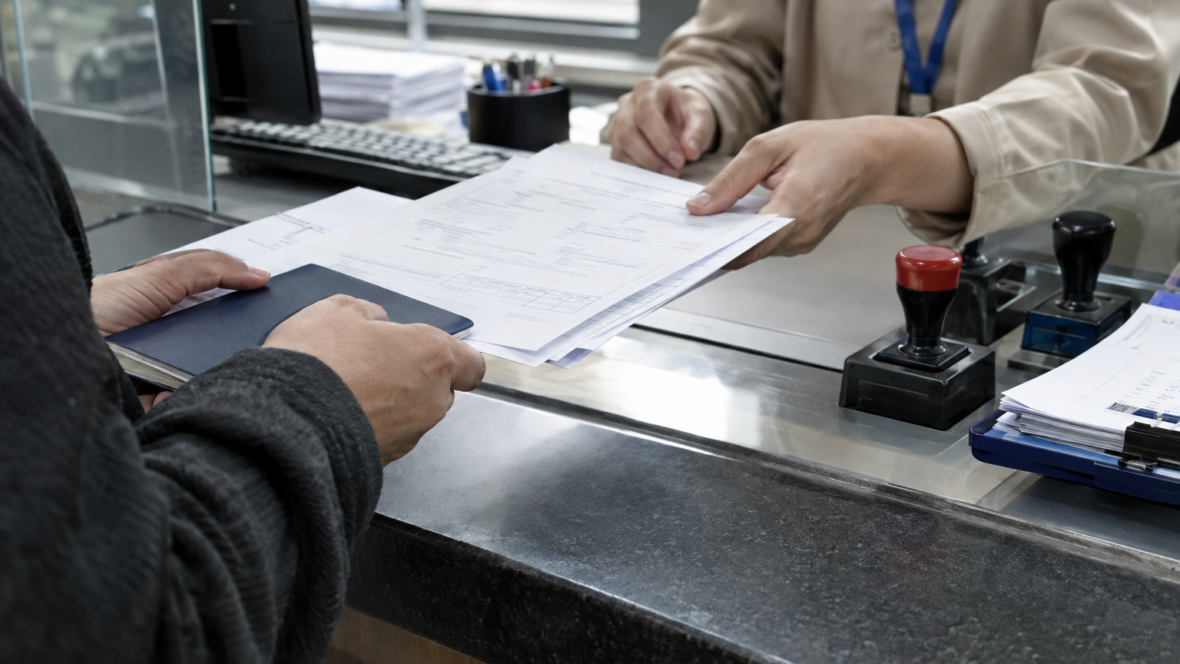 руки подають офіційні документи на стійці урядового офісу