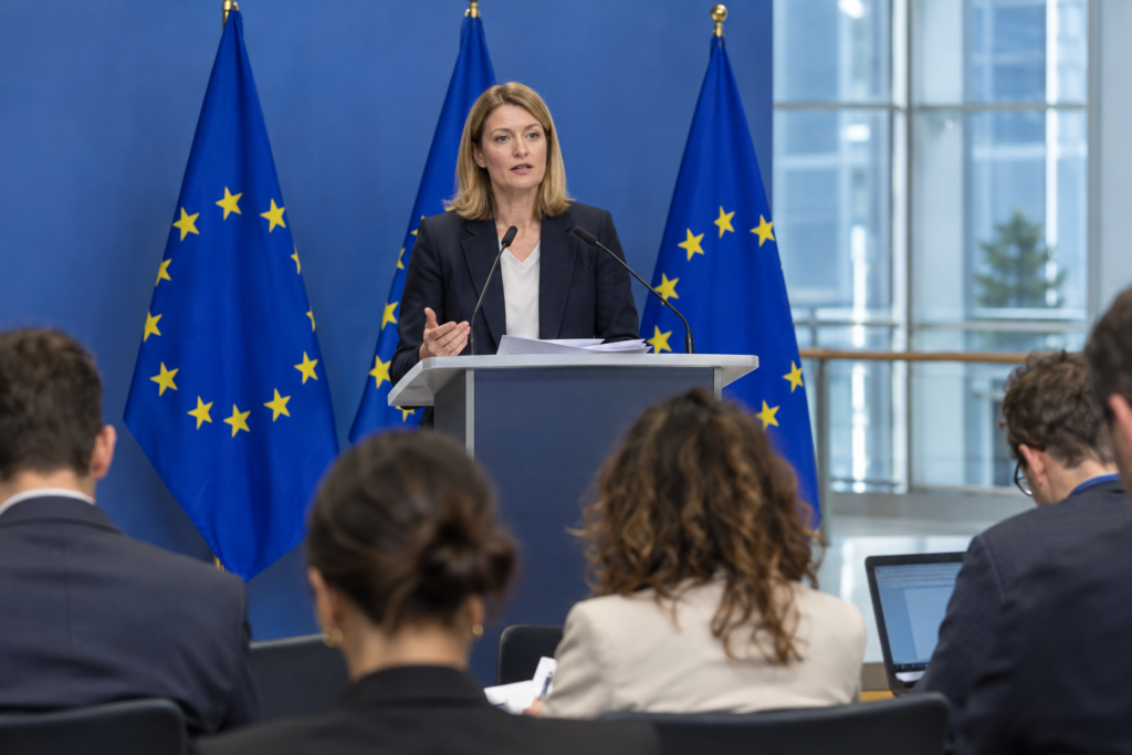 spokesperson at podium with EU flags