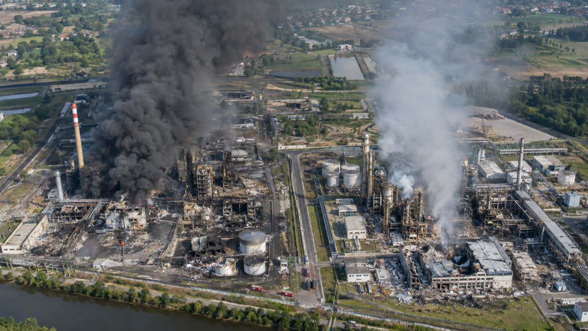 aerial view of damaged industrial plants and smoke
