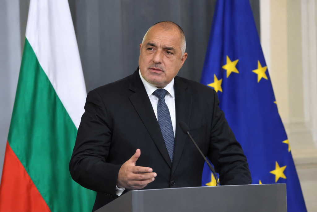 прем'єр біля трибуни з прапорами